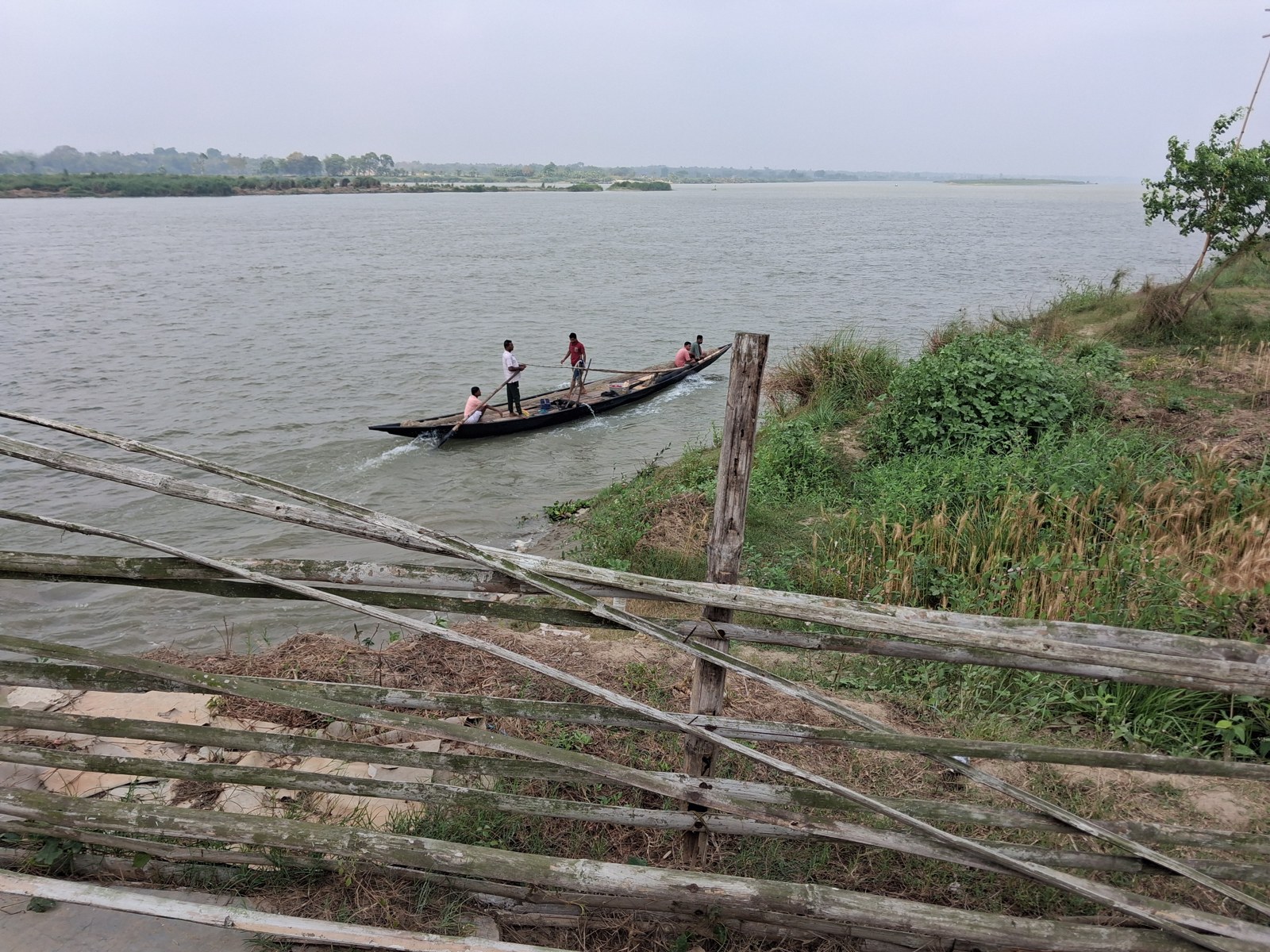 A boat beside a green riverbank in Shantipur.