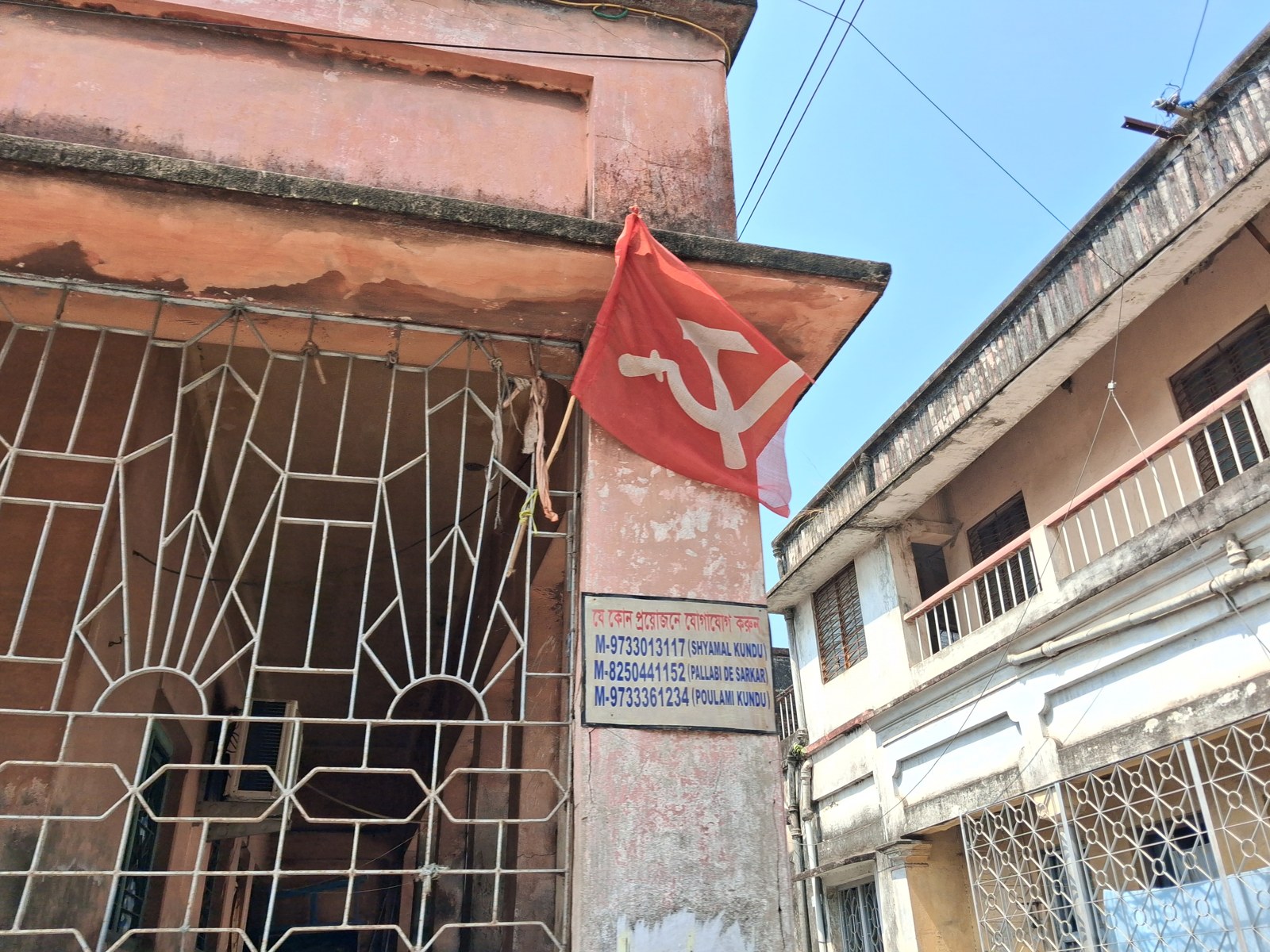 A red flag outside a building on a street in Shantipur.